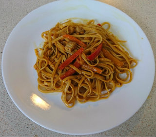 Spaghetti covered in a peanut butter sauce with shredded apple