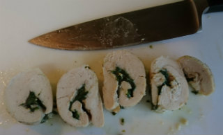 Slices of pinwheel chicken with spinach and soft cheese inside