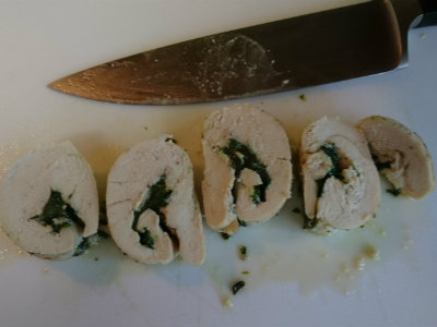 sliced chicken breast that has been rolled up with cheese and spinach inside