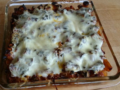 pasta with melted cheese on top in a 9-inch glass pan