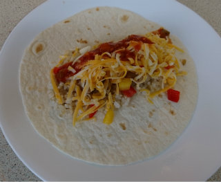 Flour tortilla with rice, diced chicken, salsa, and shredded cheese