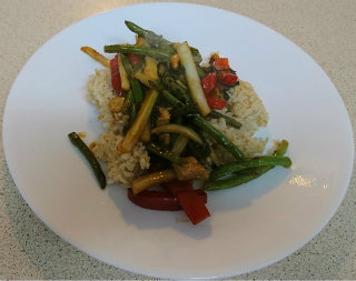 Rice topped with strips of red bell pepper, fennel, and green beans