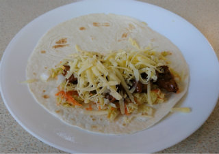 Flour tortilla with diced chicken, pickled cabbage, and shredded cheese