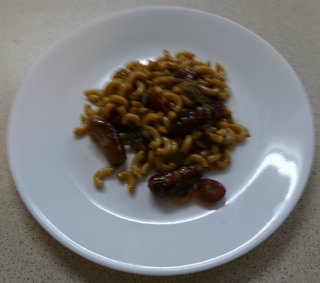 Macaroni and sliced sausage with cabbage on a plate